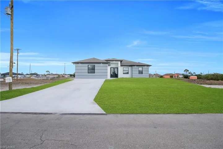 Prairie-style house featuring a front yard, concrete driveway, and roof with shingles