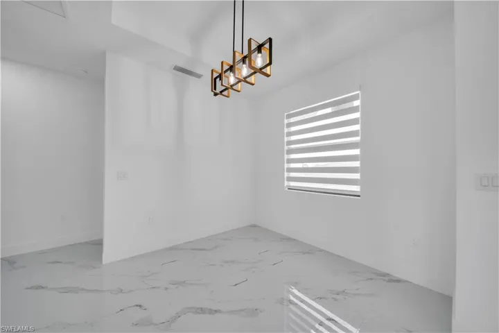Unfurnished dining area featuring light marble finish flooring and hanging lights