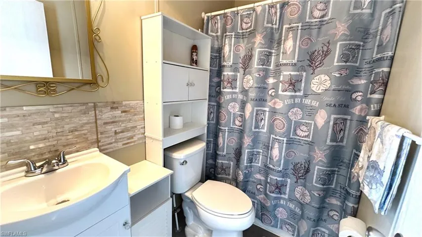Bathroom featuring tasteful backsplash, vanity, and toilet