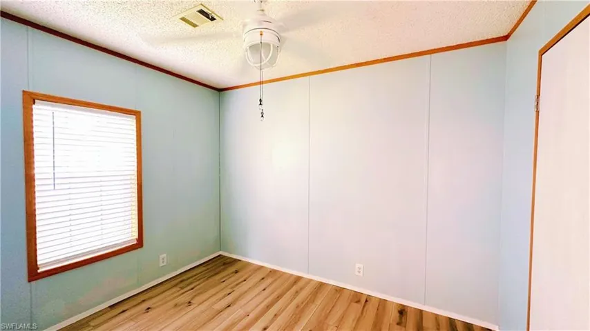 Unfurnished room with a textured ceiling and light hardwood / wood-style flooring