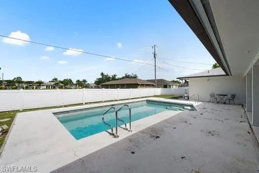 View of swimming pool featuring a patio area and a fenced backyard