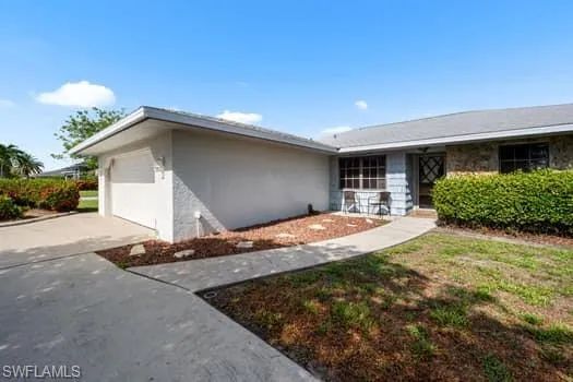 Single story home with driveway, a garage, and stucco siding