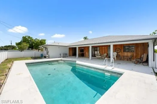 View of swimming pool with a patio and a fenced backyard