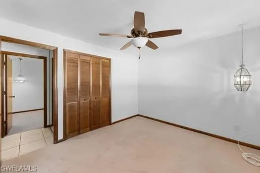 Unfurnished bedroom with a closet, ceiling fan, and light colored carpet