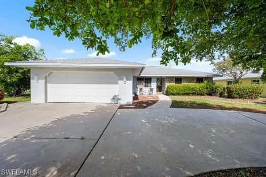 Ranch-style house featuring driveway, stucco siding, and an attached garage