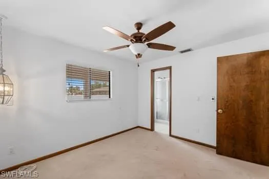 Unfurnished bedroom with light colored carpet and a ceiling fan