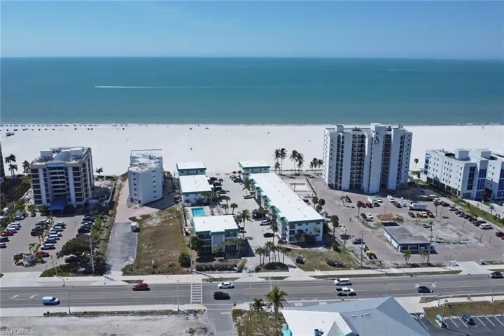 Aerial view of apartment complex / building and waterfront with a beach