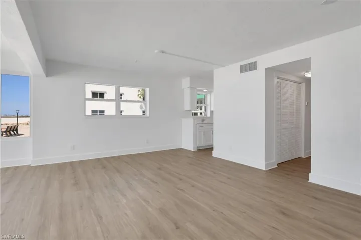 Unfurnished living room with light wood-type flooring and baseboards