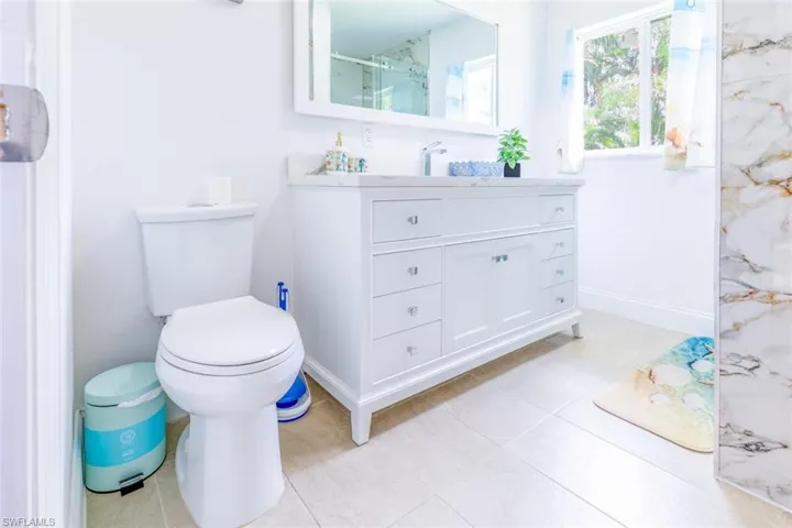 White vanity with a light countertop, under-mount sink, and chrome fixtures