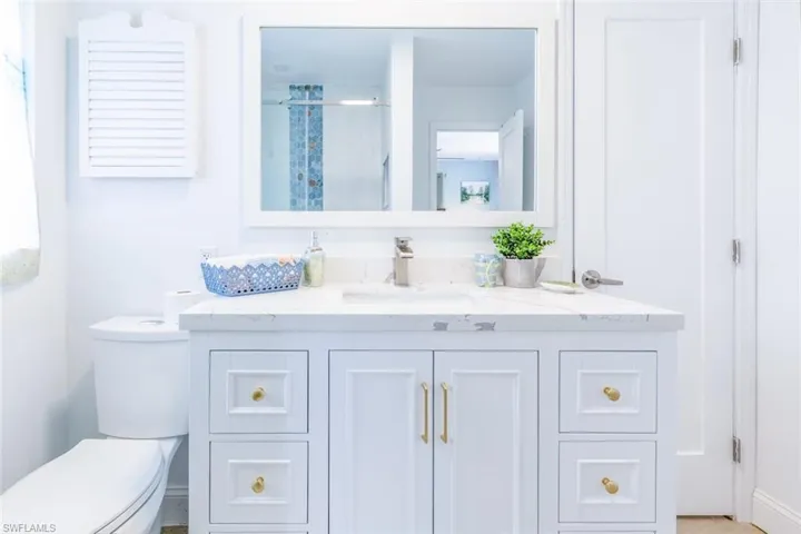 White vanity with a light-colored countertop and under-mount sink