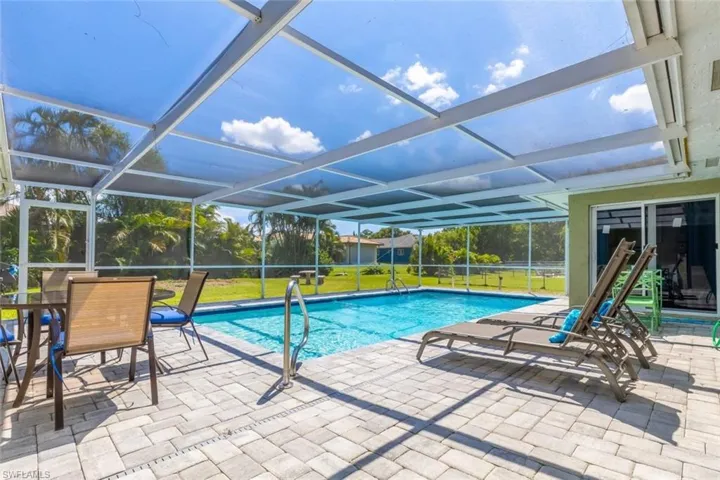 Screened lanai featuring a swimming pool, paver deck, and transparent roof panels