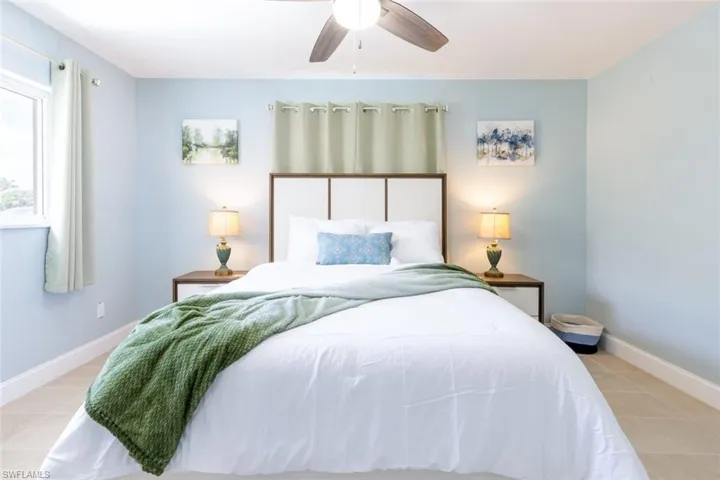 Bedroom featuring a ceiling fan, light blue walls, and tile flooring