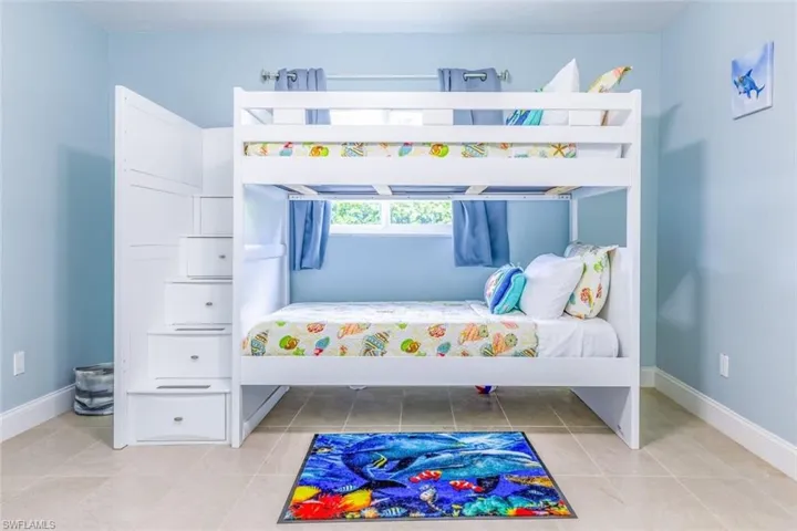 White bunk bed structure featuring integrated stair storage