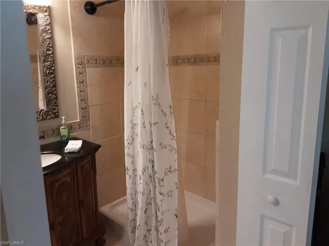 Full bathroom featuring vanity and tiled shower