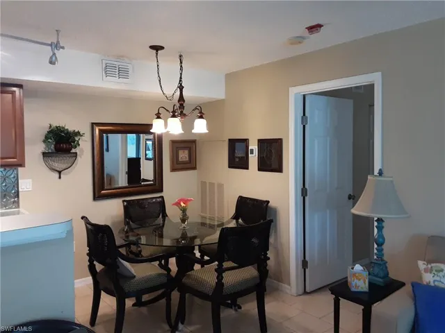 Dining room with baseboards, chandelier, and light tile patterned flooring