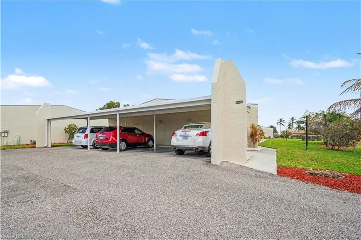 Covered carport with storage closet attached to the building.