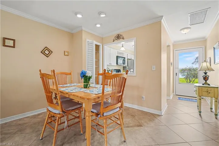 Dining area featuring tile flooring, crown molding and added pantry closet.
