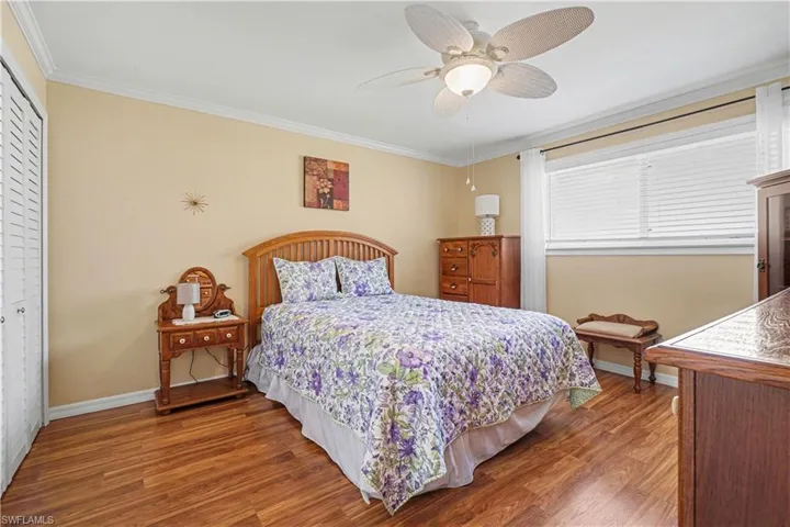 Primary Bedroom featuring Pergo flooring, 2 closets, ceiling fan and primary bath.