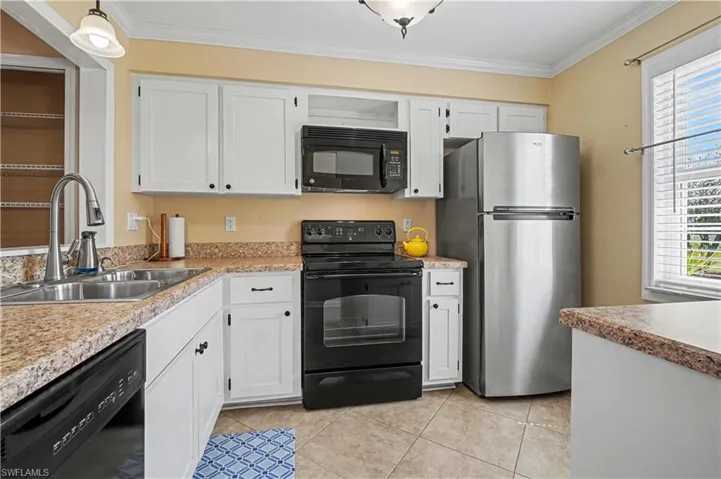 Kitchen view from entry hallway with a pass through to the dining area.