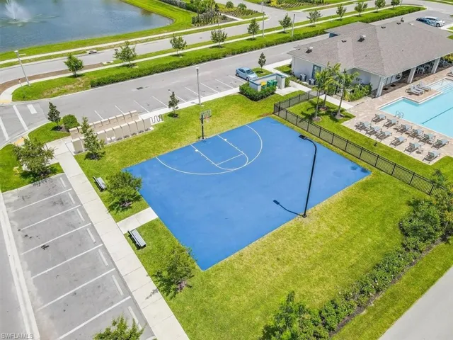 View of sport court featuring community basketball court, a fenced backyard, a water view, and a patio area