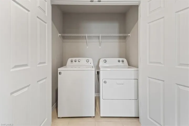 Laundry area featuring washer and dryer and light tile patterned floors