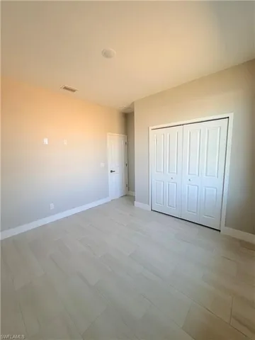 Unfurnished bedroom with baseboards and a closet