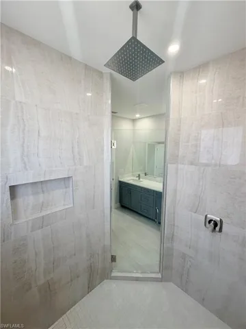 Bathroom with double vanity, a stall shower, and recessed lighting
