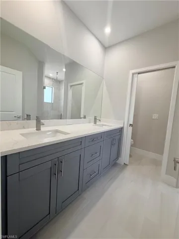 Full bath with double vanity and a stall shower