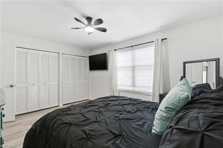 Guest bedroom featuring 2 closets, ceiling fan and light flooring