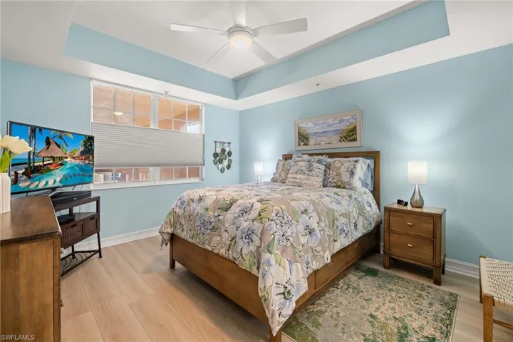 Primary bedroom with tray ceiling and new fan and flooring
