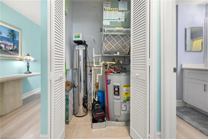 Utility area showing booster pump and Halo water filtration system.  New water heater 2023.  AC  2020