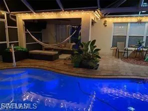 Swimming pool with a patio area, a sunroom, and glass enclosure