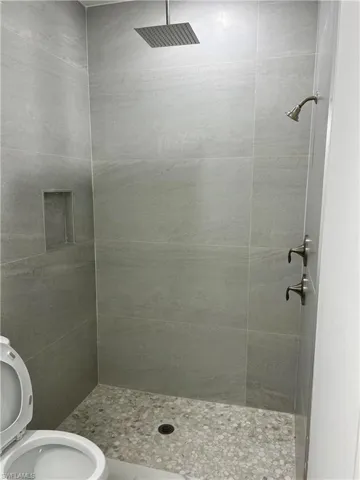 Bathroom with tiled shower and toilet