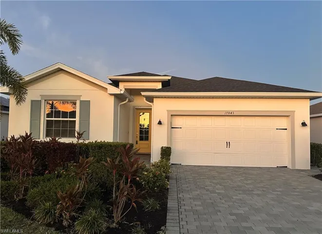View of front of house featuring decorative driveway, stucco siding, a garage, and roof with shingles