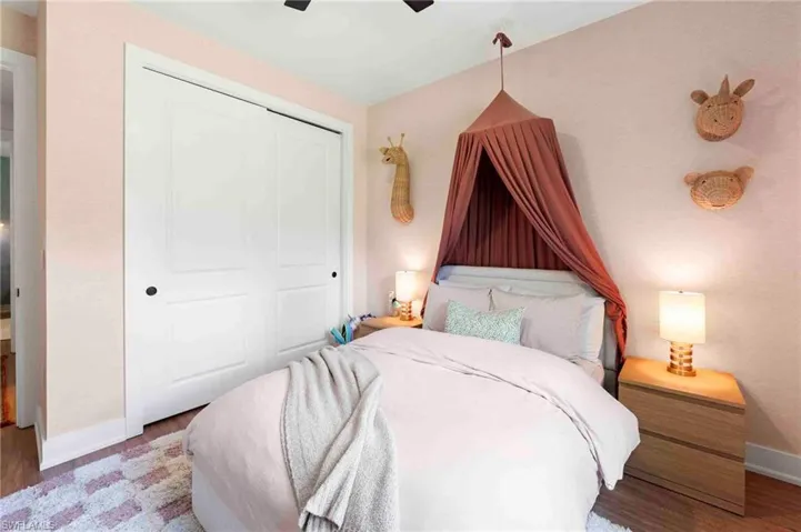 Bedroom featuring wood-finish flooring and a white sliding closet door