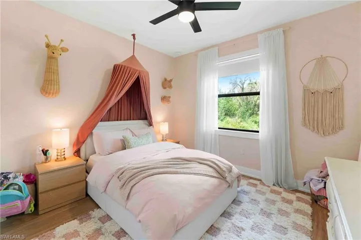 Room with window, ceiling fan, and wood-finish flooring
