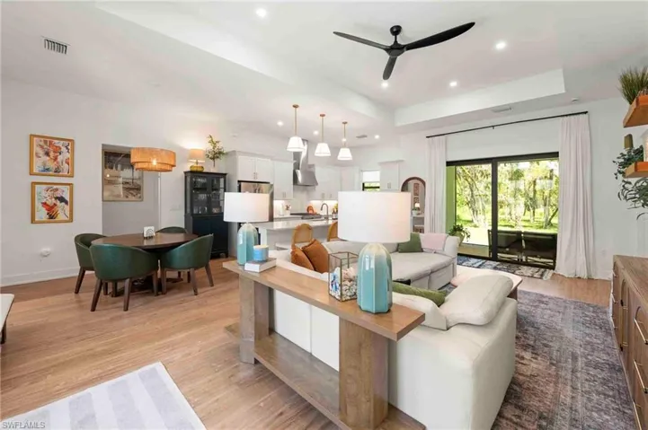 Open-concept living space featuring wood-finish flooring, recessed lighting, a modern ceiling fan, and sliding glass doors to the exterior