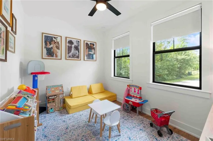 Room featuring two windows, a ceiling fan, and wood-finish flooring