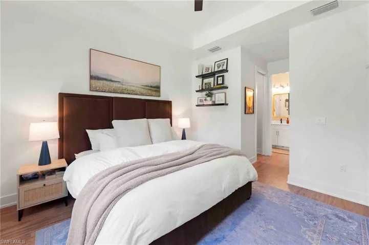 Wood-finish flooring throughout, tray ceiling, recessed lighting, and built-in shelving