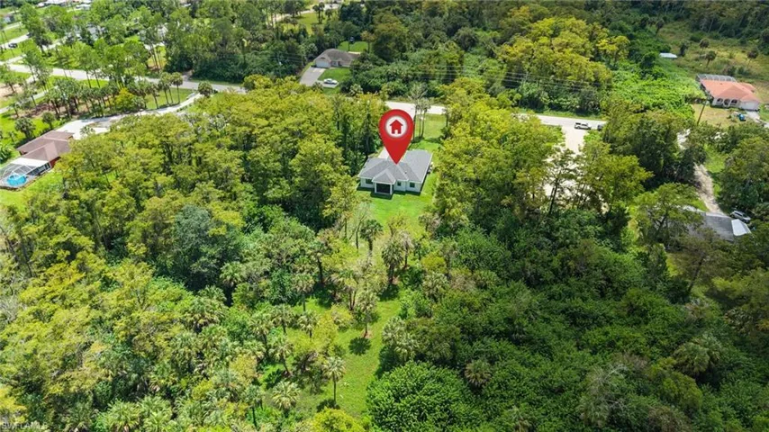 Expansive lot featuring a single-story residence with a light gray exterior and dark roof