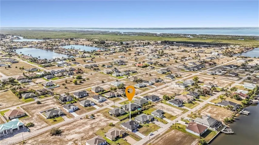 Aerial view of property and surrounding area featuring a nearby body of water and nearby suburban area