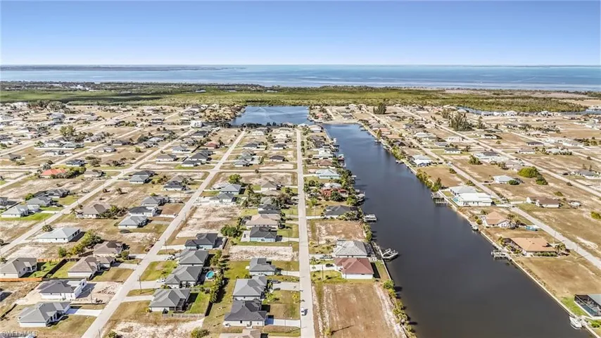 Aerial view of property's location with a large body of water and nearby suburban area