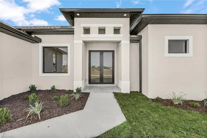 Doorway to property featuring french doors and stucco siding