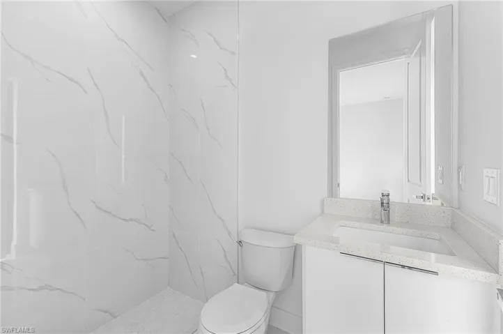 Full bath with vanity and a marble finish shower