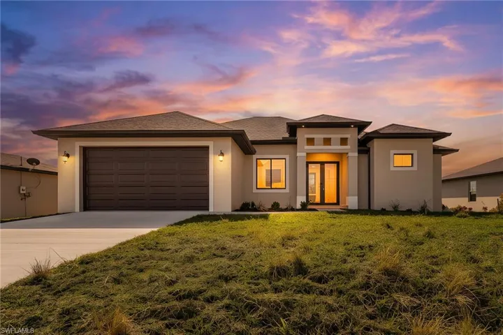 Prairie-style home with concrete driveway, an attached garage, stucco siding, and a front yard