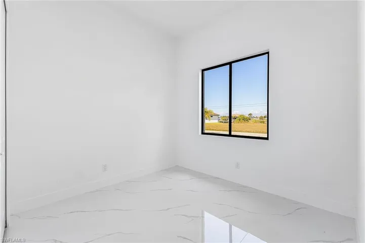 Unfurnished room featuring baseboards and light marble finish floors