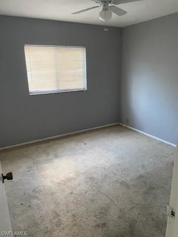 Unfurnished room featuring carpet and ceiling fan