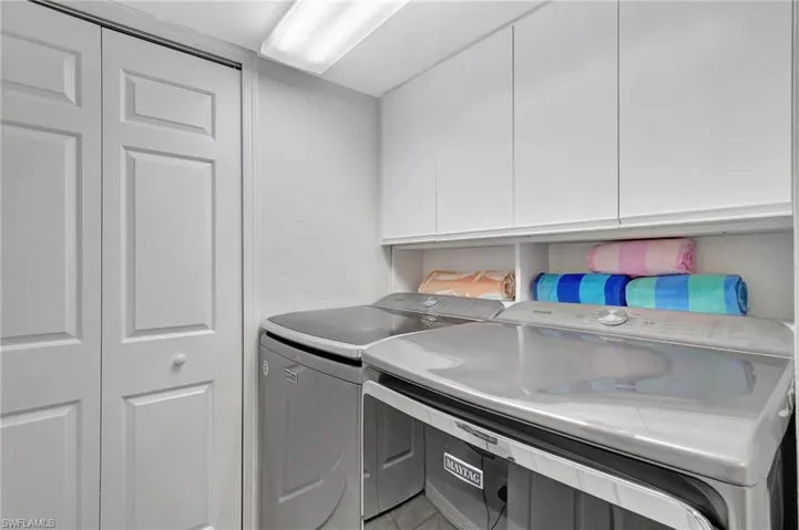 Laundry room featuring cabinets and washer and clothes dryer