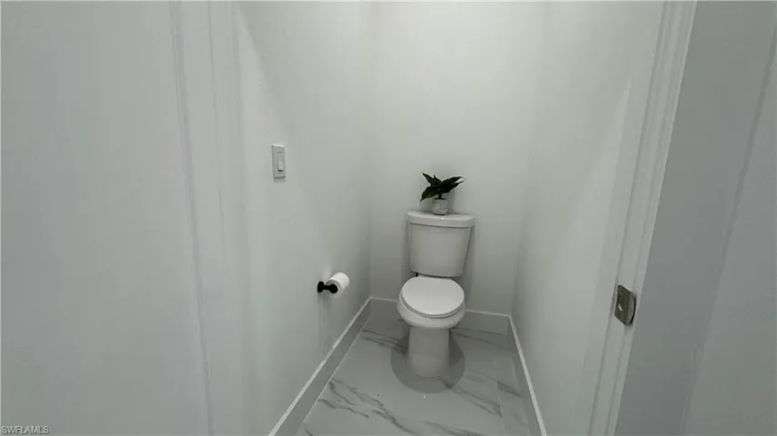 Bathroom with baseboards and marble look tile flooring