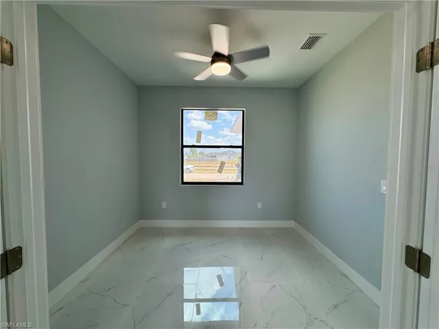 Spare room featuring baseboards and light marble finish flooring